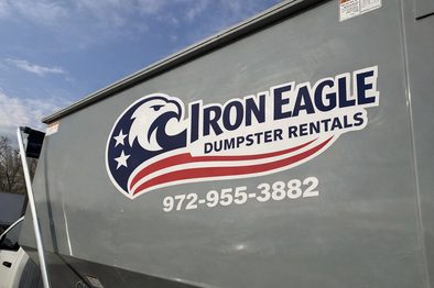 Roll-off dumpster placed under a covered driveway for a remodel project