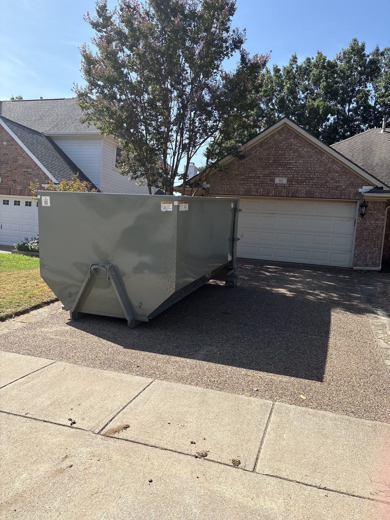 Iron Eagle Dumpster Rentals branded roll-off dumpster on a residential driveway